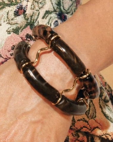 Close-up of the Écaille beaded cuffs in dark brown, worn