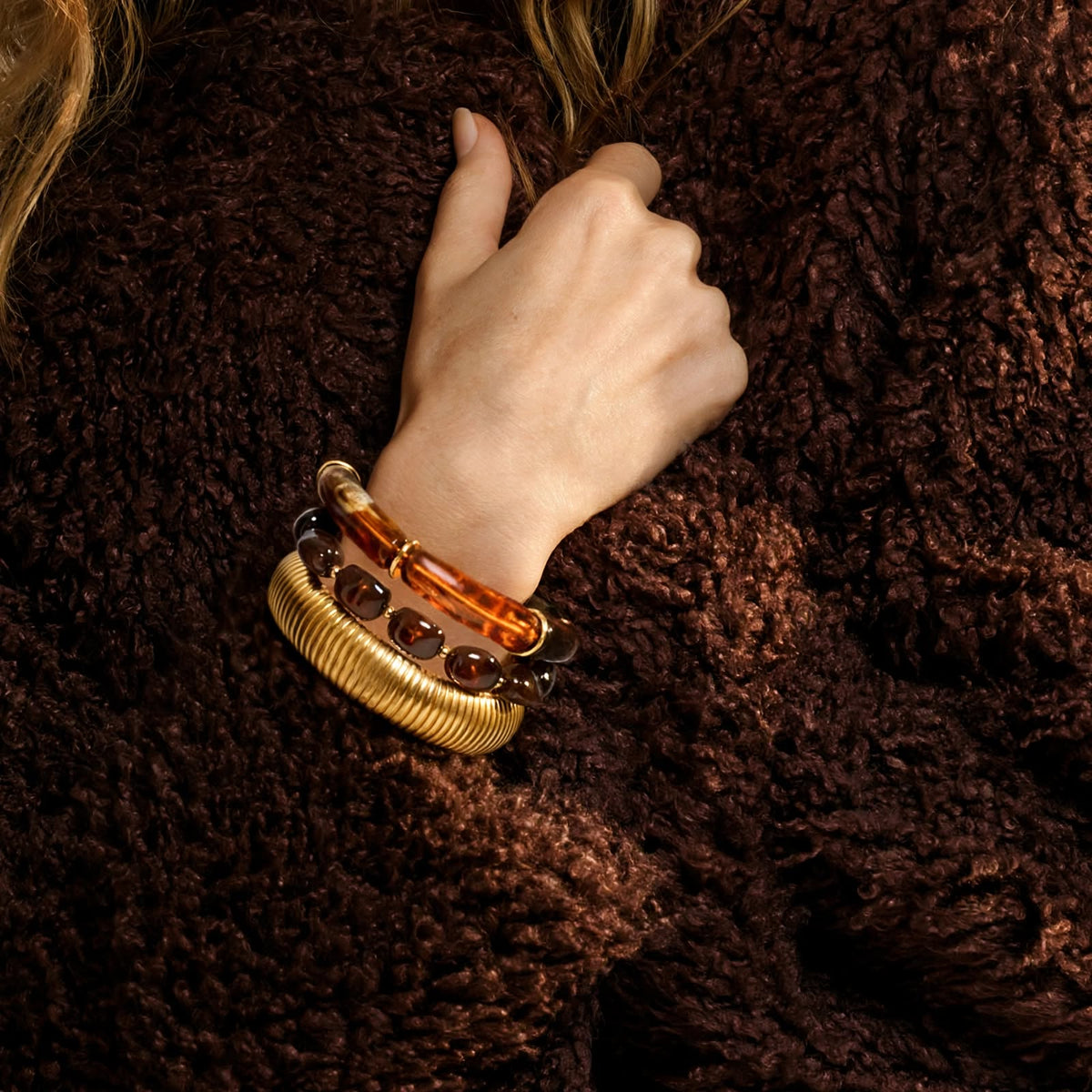 Audace Wide Cuff worn stacked with the Ecaille Beaded Cuff against brown shearling