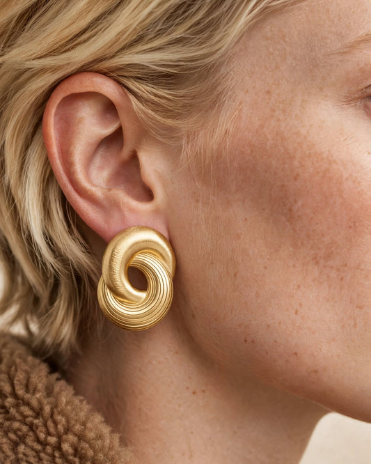 Infinity Twist Earrings in gold, worn on the ear