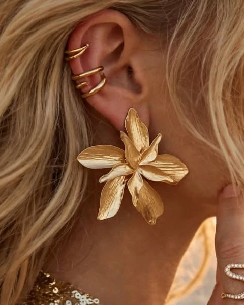 Close-up of the Orchidée earring in gold, worn