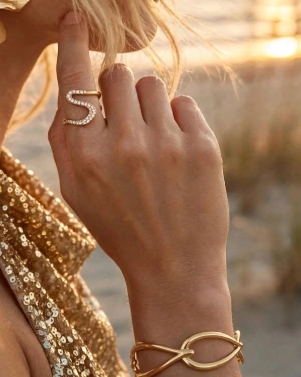 Close-up of the pavé wave ring and Goutte bangle in gold, worn